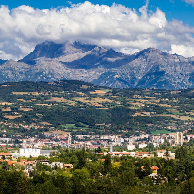 The city of Gap in the Hautes Alpes with surrounding mountains and peaks in Summer. Panoramic. Southern French Alps, France