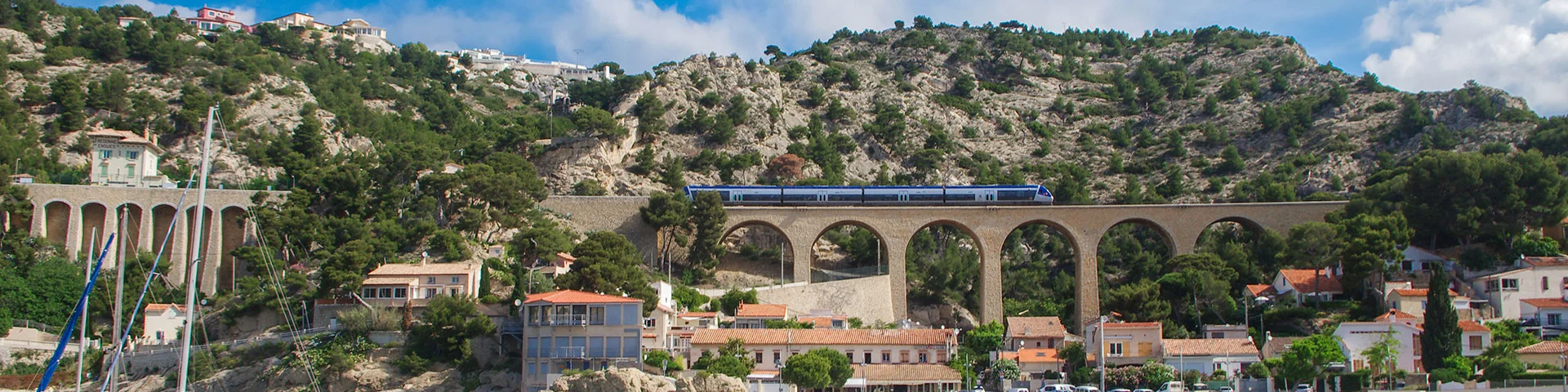 Vue du port d'Ensuès-la-Redonne et du train passant sur le viaduc et ses arcades