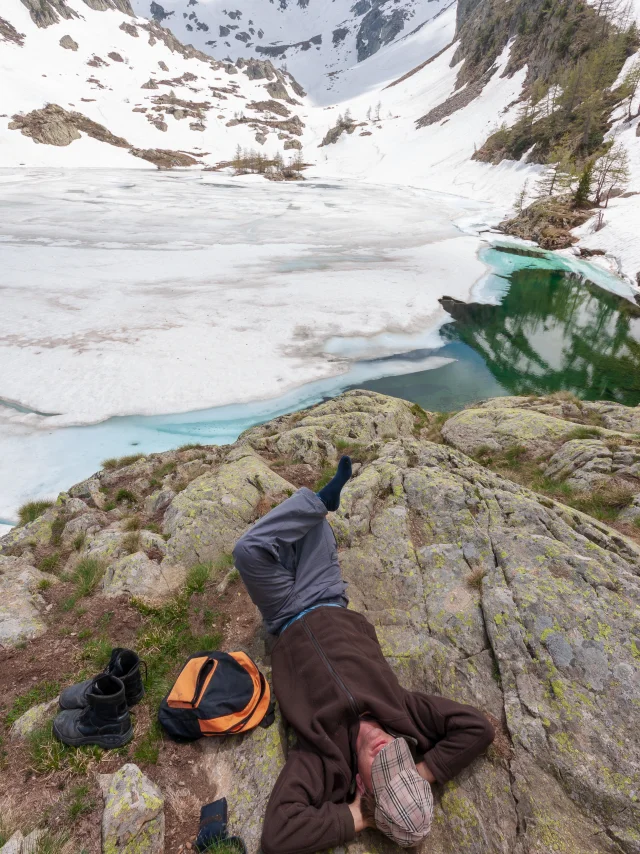 Un homme se repose au bord d'un lac gelé