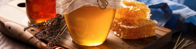 Honey in jar and bunch of dry lavender