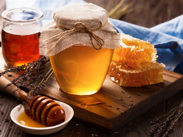 Honey in jar and bunch of dry lavender