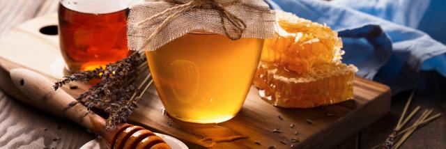 Honey in jar and bunch of dry lavender