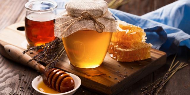 Honey in jar and bunch of dry lavender