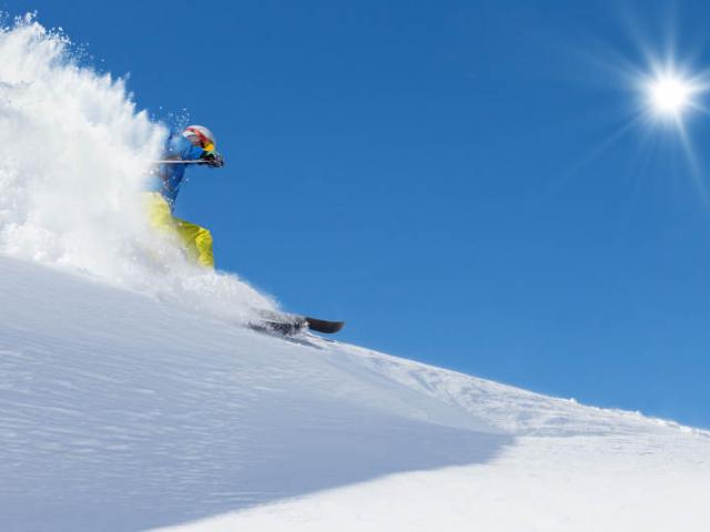 Skier skiing downhill in high mountains