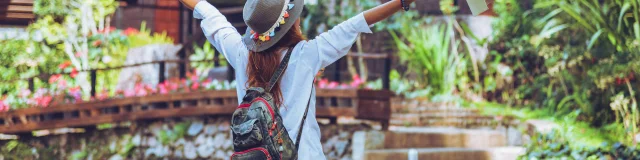 Freedom traveler woman standing with raised a book in hand arms and enjoying a beautiful nature. space for text.