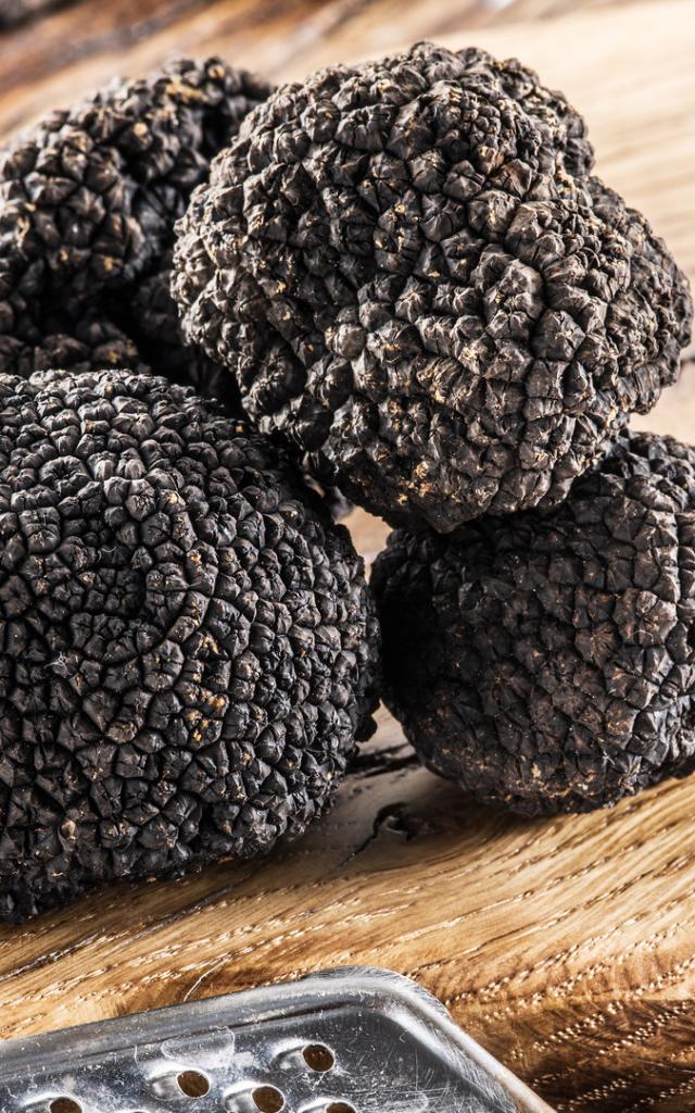 Black truffles on the old wooden table.