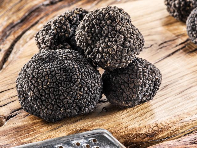 Black truffles on the old wooden table.