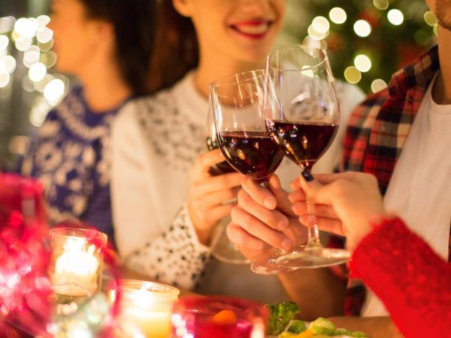 close up of friends with wine celebrate christmas