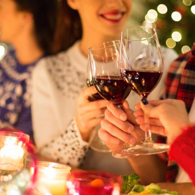 close up of friends with wine celebrate christmas