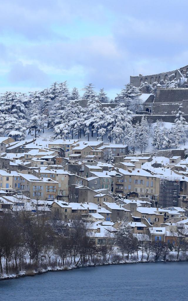 Vue sur Sisteron sous la neige, la citadelle et la Durance en premier plan, dans les Alpes de Haute Provence