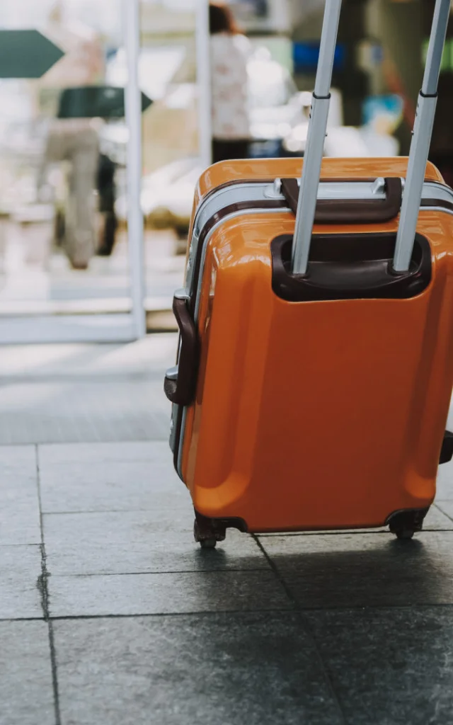 Close-up of man walking with suitcase. He is going in departure lounge. Copy space in left side