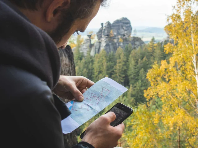 Homme cherchant des informations sur le risque incendie en forêt sur son smartphone