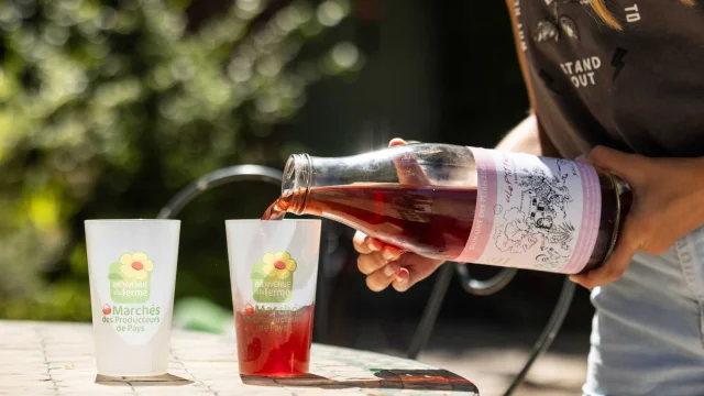 Close-up of fruit juice poured into a Bienvenue à la ferme ecocup