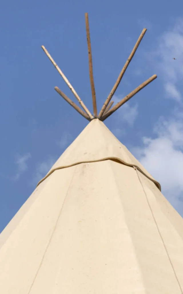 Top of a tipi against a blue sky