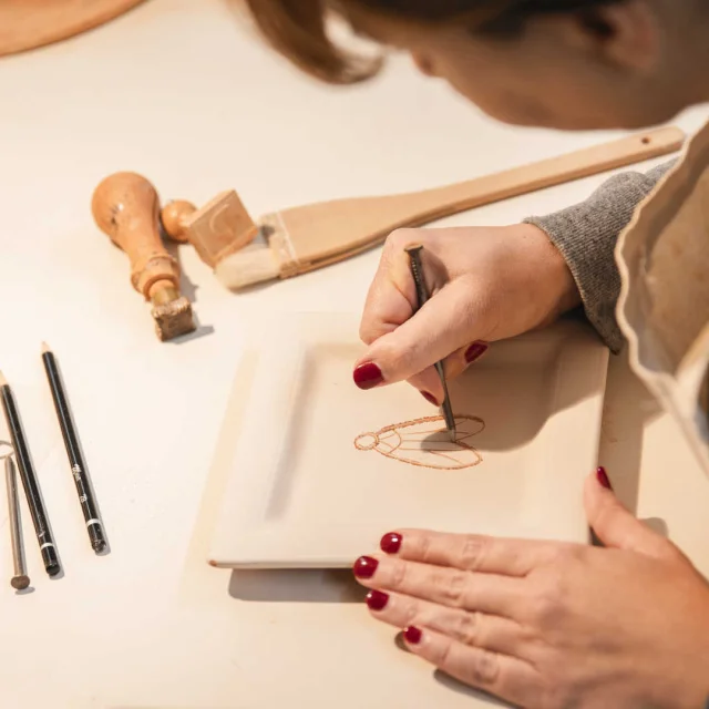 Dessin au clou d'une cigale sur une assiette, à la main