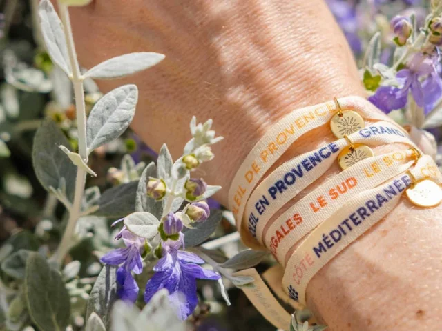 Plusieurs bracelets rubans sur un poignet dans les fleurs