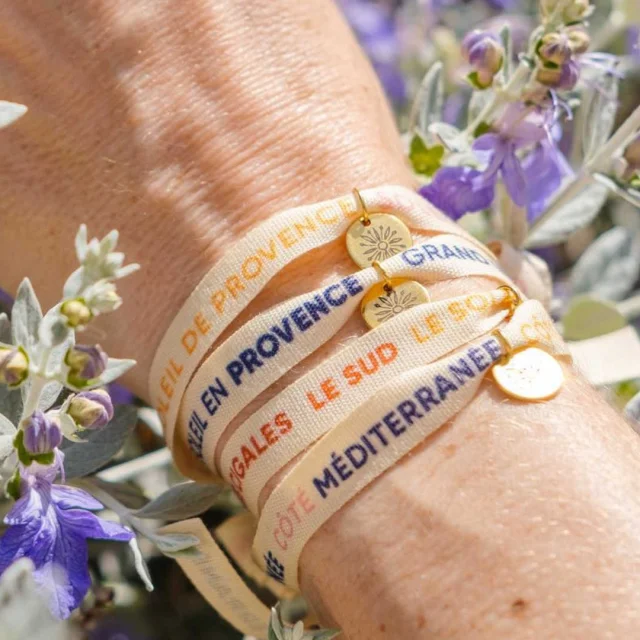 Plusieurs bracelets rubans sur un poignet dans les fleurs