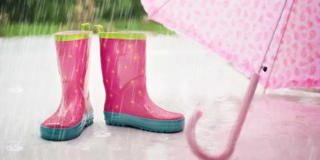 Bottes de pluie et parapluie roses pour enfant sous la pluie