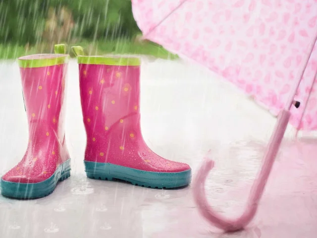 Bottes de pluie et parapluie roses pour enfant sous la pluie