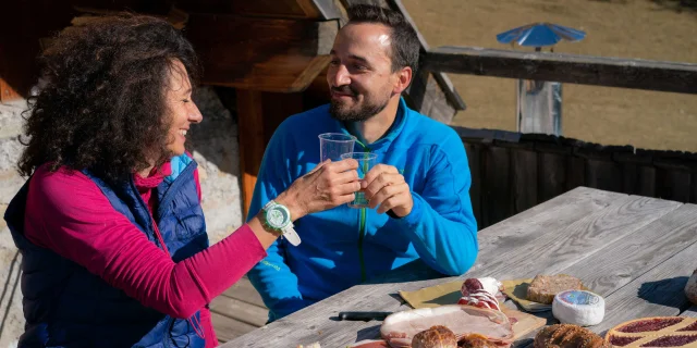 Couple de randonneurs en pause déjeuner à la terrasse d'un refuge