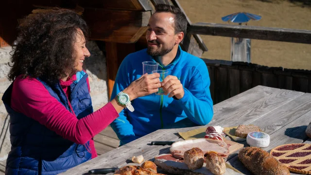 Wandererpaar bei der Mittagspause auf der Terrasse einer Berghütte