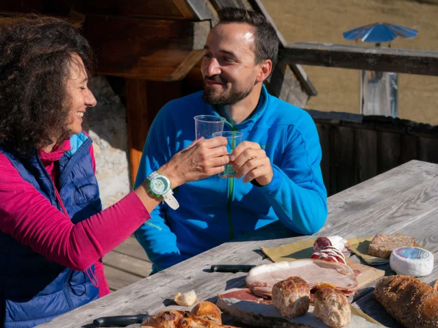 Couple de randonneurs en pause déjeuner à la terrasse d'un refuge