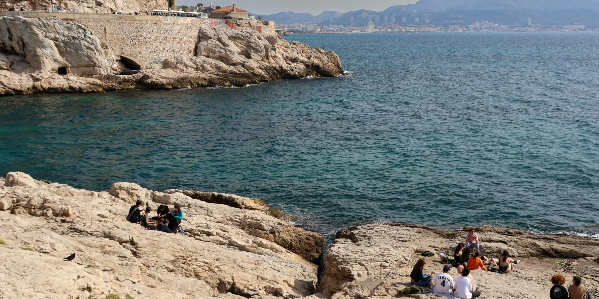 Petit groupe de personnes sur les rochers en bord de mer à Marseille