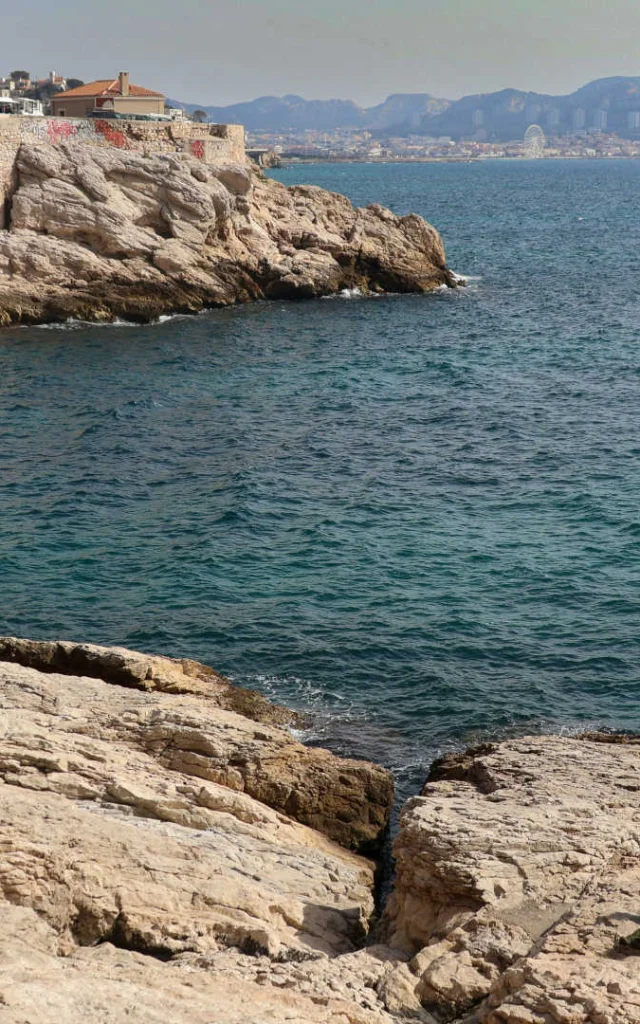 Small group of people on the rocks by the sea in Marseille
