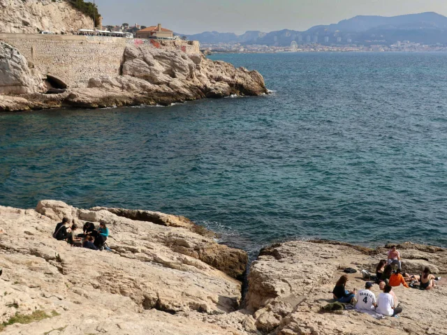 Petit groupe de personnes sur les rochers en bord de mer à Marseille