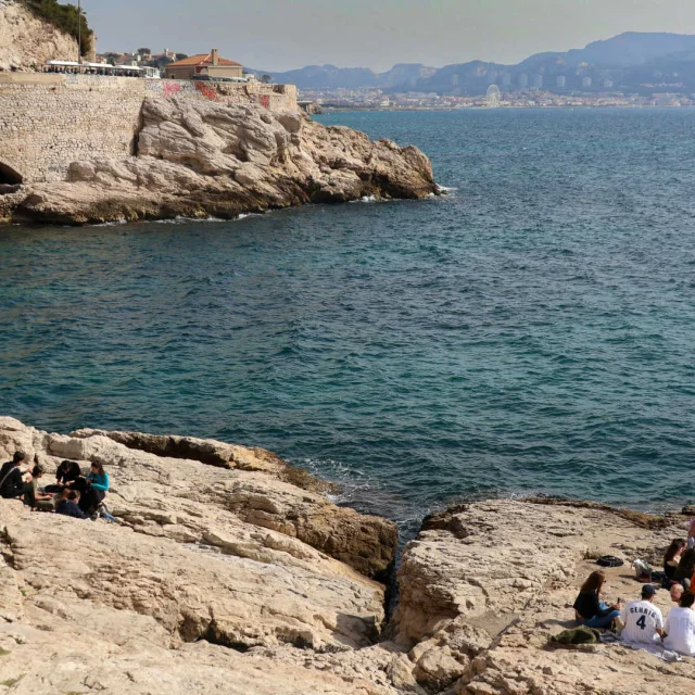 Petit groupe de personnes sur les rochers en bord de mer à Marseille