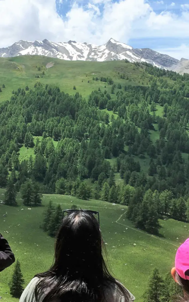 Une mère et son fils qui observe les vallon verdoyant de Lauzanier avec des jumelles