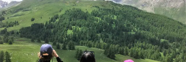 Une mère et son fils qui observe les vallon verdoyant de Lauzanier avec des jumelles