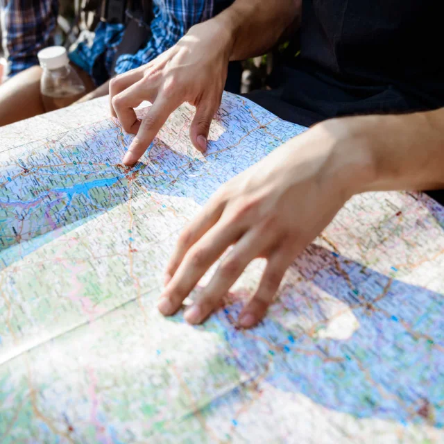 Un groupe d'amis qui consultent une carte routière au soleil