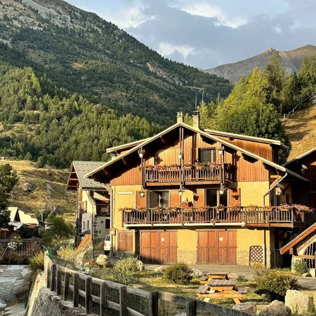 Maisons en bois du village de Ceillac devant la montagne au coucher du soleil