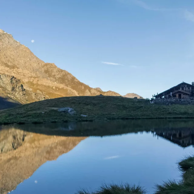 Reflet du refuge de la Blanche et du paysage dans le lac, en fin de journée