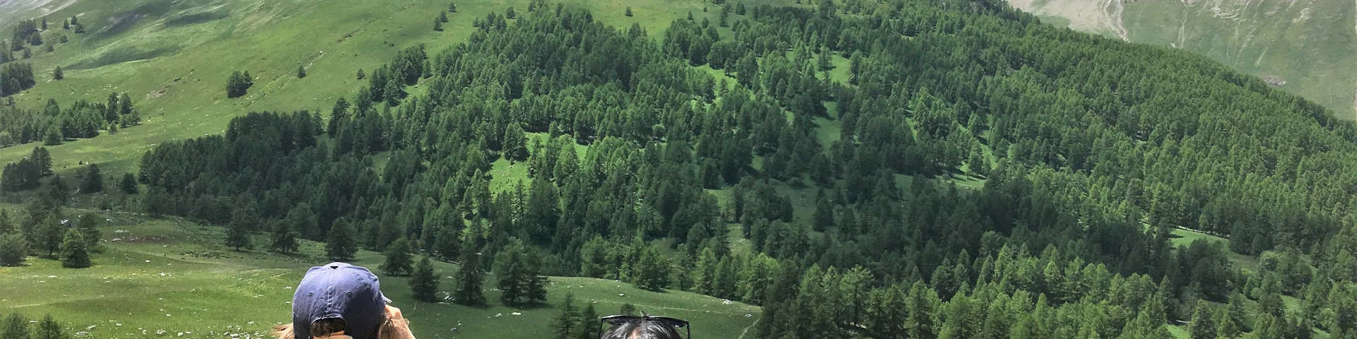 Une mère et son fils qui observe les vallon verdoyant de Lauzanier avec des jumelles