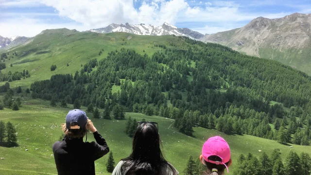 Une mère et son fils qui observe les vallon verdoyant de Lauzanier avec des jumelles