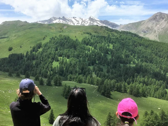 Une mère et son fils qui observe les vallon verdoyant de Lauzanier avec des jumelles