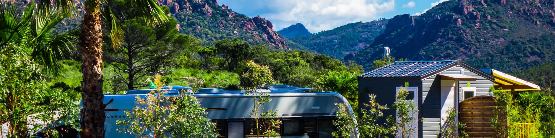 Une caravane au camping Caravaning d'Agay, entre verdure et roches rouges de l'Estérel