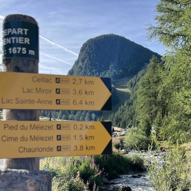 Panneau des itinéraires de randonnée à Ceillac devant un décor alpin