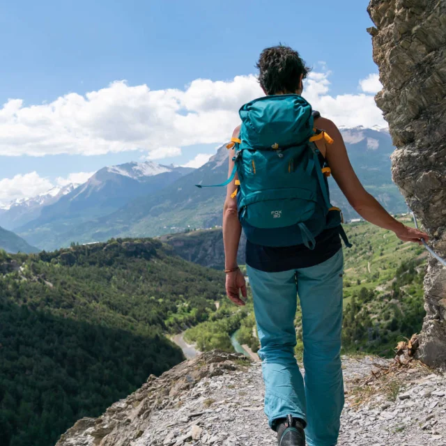 Wanderin, die einen Handlauf auf einem Wanderweg im Queyras hält.