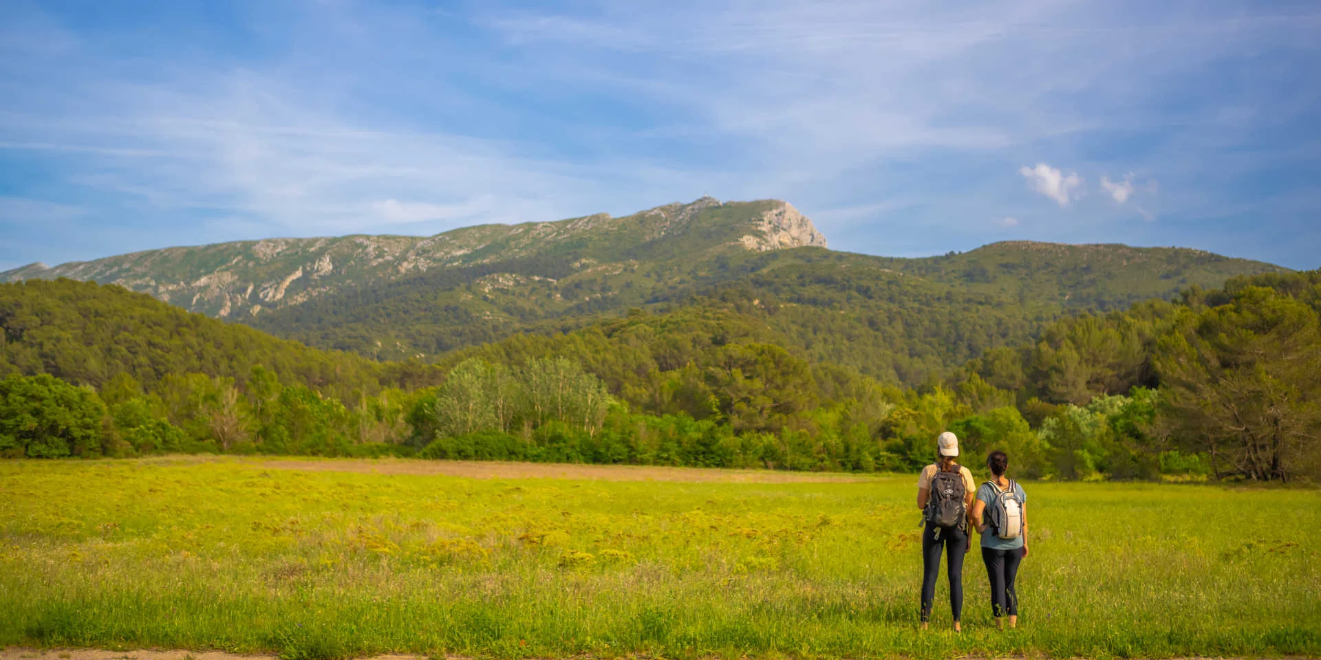 Deux randonneuses de dos qui admirent le massif de la Sainte-Victoire
