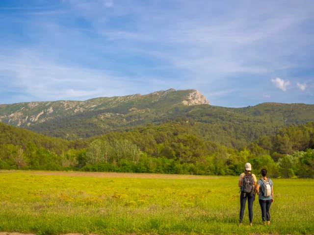 Deux randonneuses de dos qui admirent le massif de la Sainte-Victoire