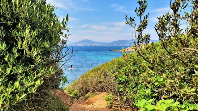 Le sentier du littoral de Giens qui débouche sur une vue mer avec un paddle sur l'eau
