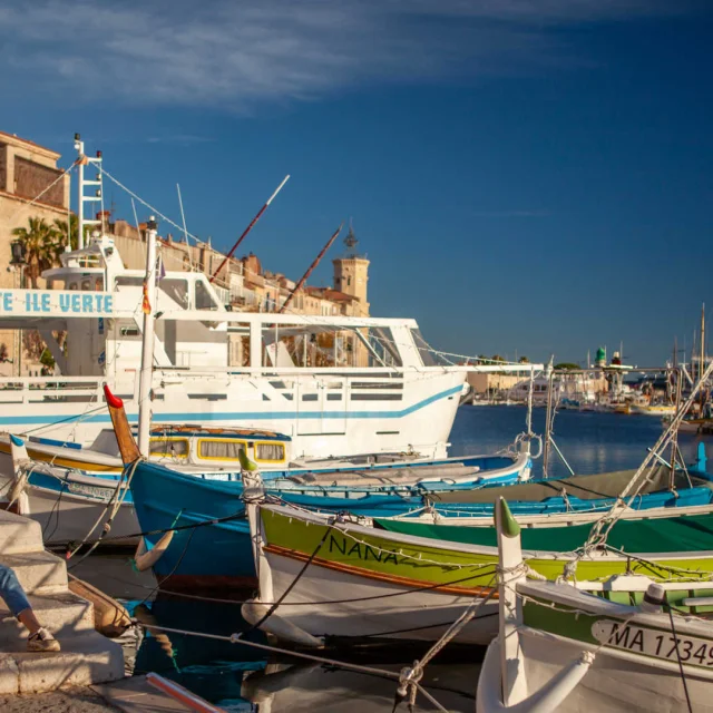 Un couple assis près des pointus du port de La Ciotat