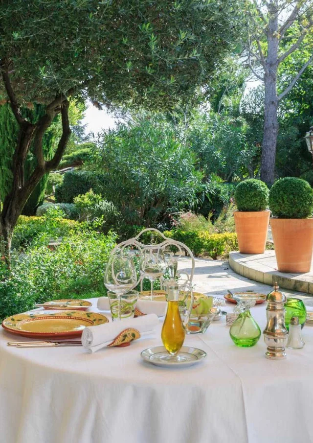 Une table dressée dans le jardin verdoyant de l'Auberge de Cassagne