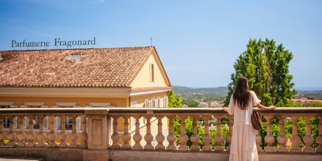 Une femme qui observe la vue devant l'usine de la Parfumerie Fragonard