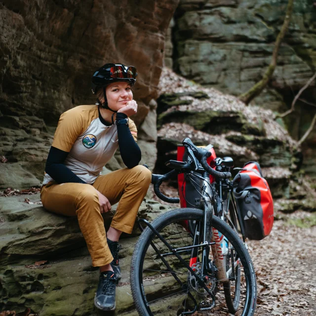 Eline Le Menestrel assise à côté de son vélo, en bas des voies d'escalade