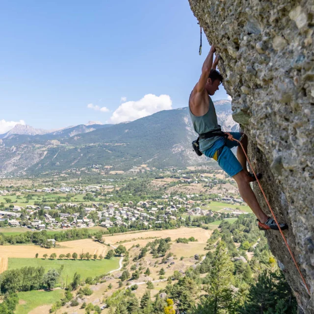 A climber scaling above Mont-Dauphin