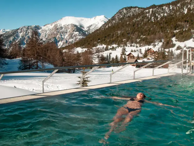 Une femme se baigne dans le bassin extérieur du Durancia Balneo Spa Nuxe de Montgenèvre